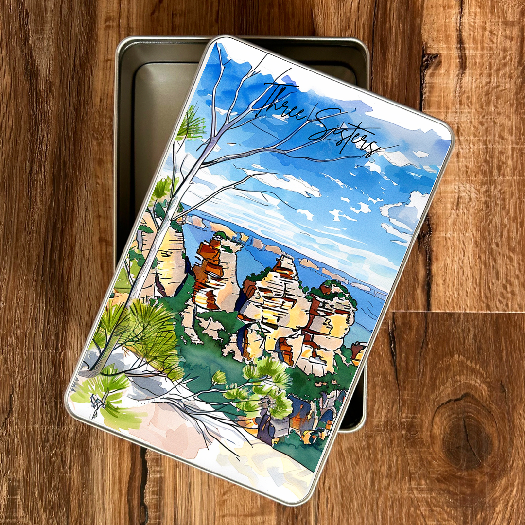 Piccola Gift tin with a scenic illustration of the three sisters katoomba blue mountains on a wooden surface