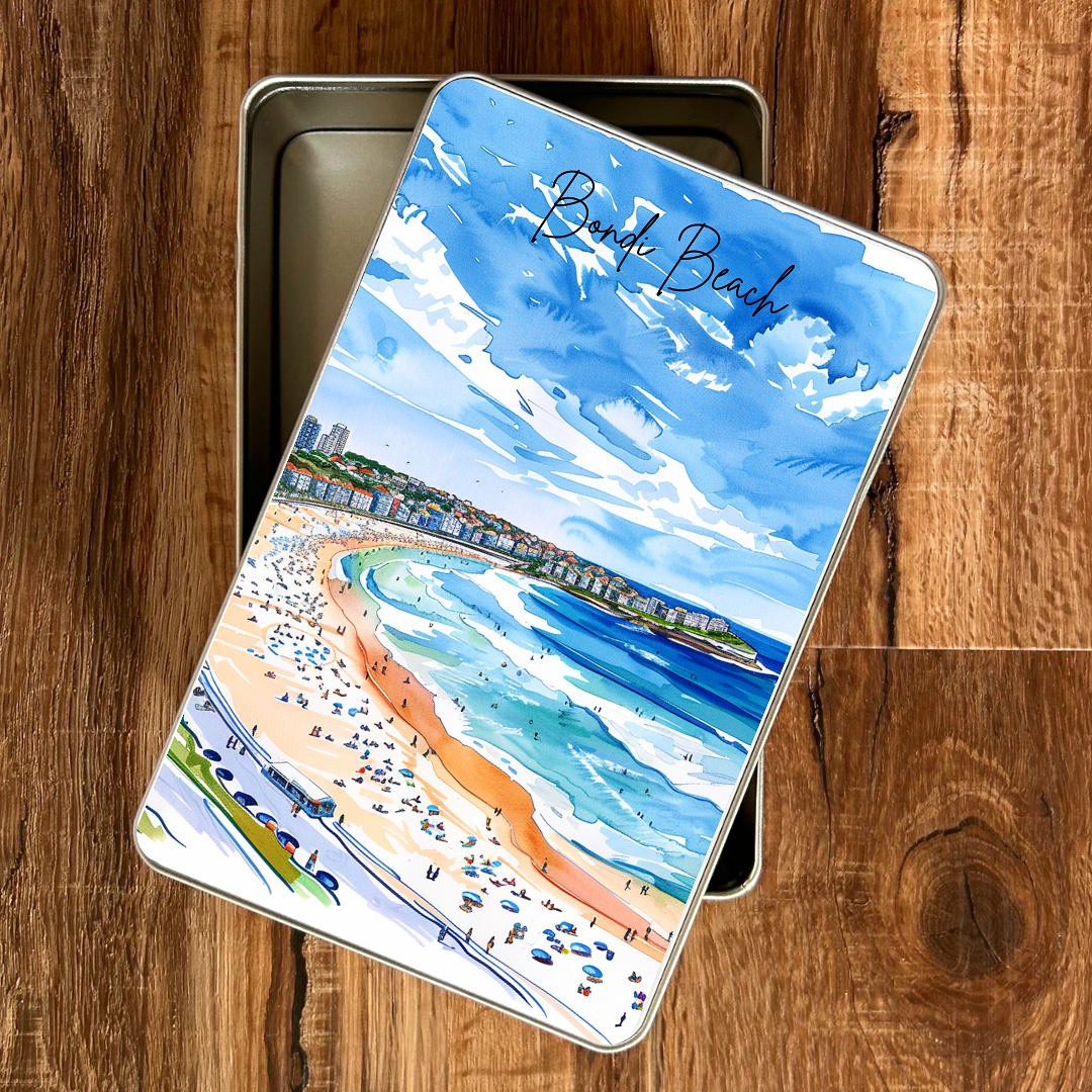Piccola gift tin with a bondi beach illustration on a wooden surface
