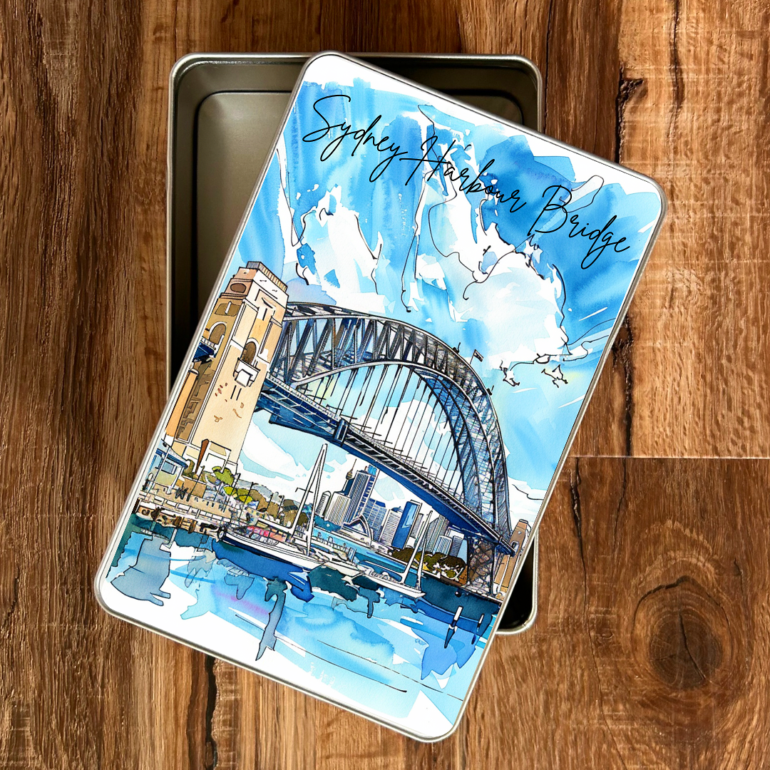 Piccola gift tin with Sydney Harbour Bridge illustration on a wooden surface