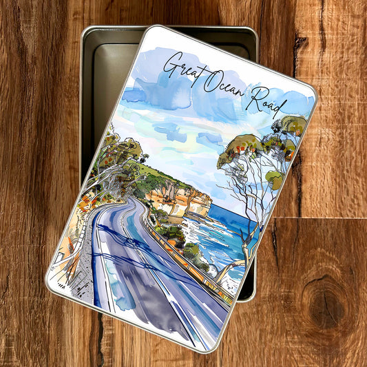 Piccola gift tin with a Great Ocean Road illustration on a wooden surface